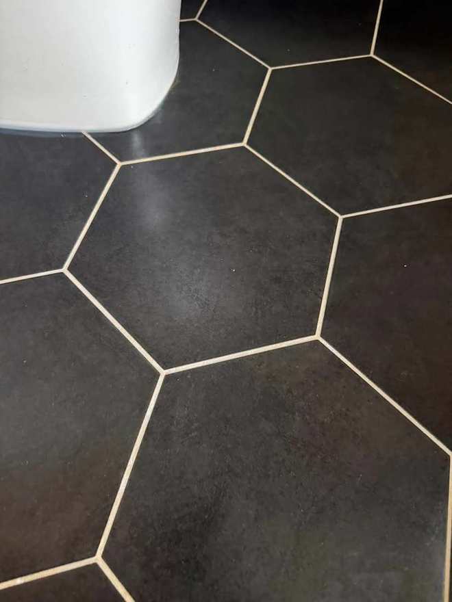 The same black hexagon tile floor washed and buffed to an even finish