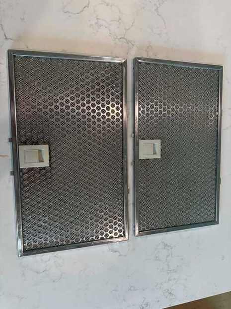 The same two range hood filters back to bare metal after degreasing