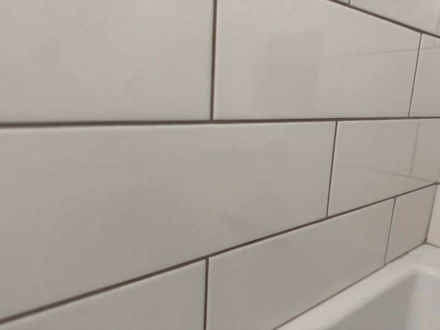 The same white tile with the grout lines brought back to a clean, even tone